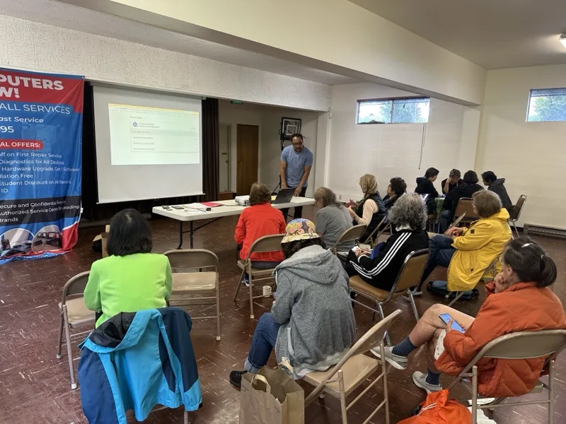 Community technology presentation with attendees seated facing a projection screen